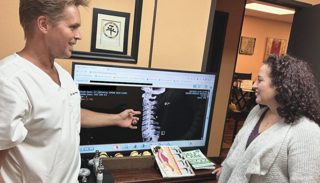 Dr. Thomas Polucki reviewing posture and recovery progress with a patient during a chiropractic visit in Santa Clarita.